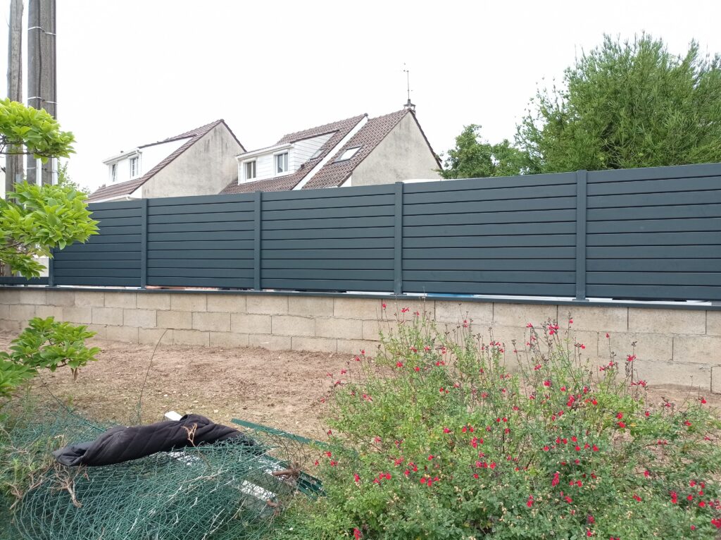 Palissade aluminium posée sur un muret béton par PML Menuiserie
