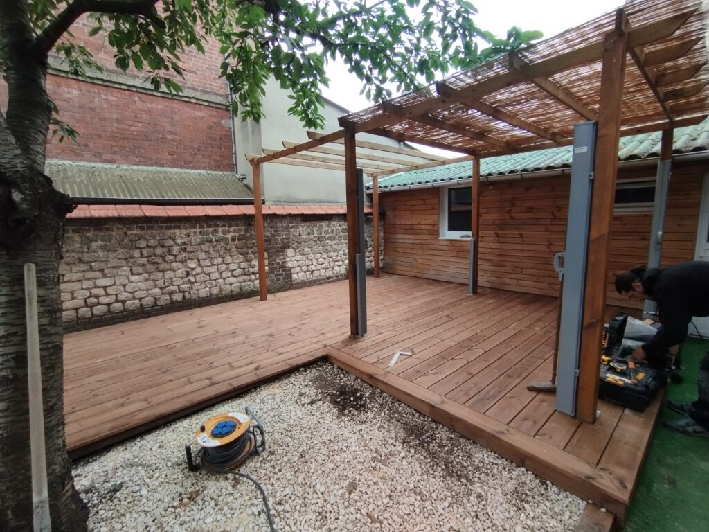 Terrasse en pin aménagée autour d’un arbre par PML Menuiserie