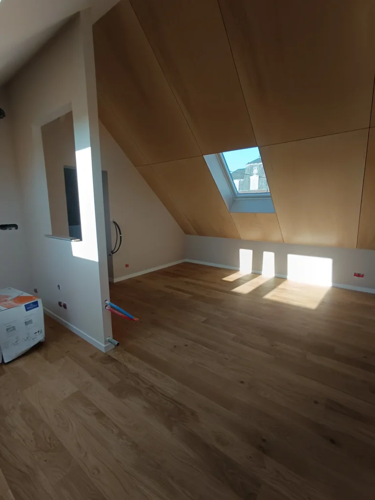 Rampant habillé en contreplaqué au-dessus d’un parquet en chêne dans des combles