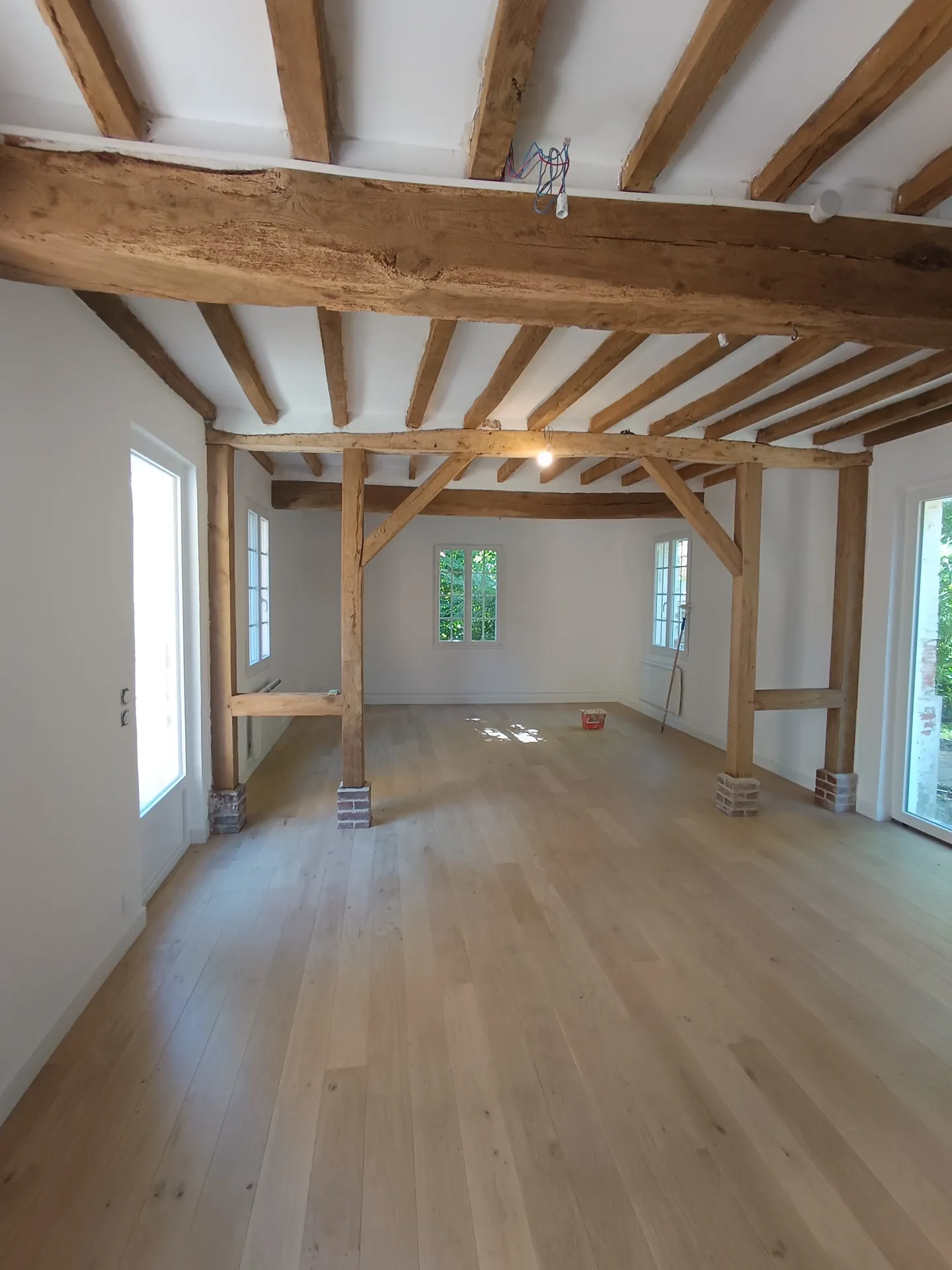 Parquet en chêne massif sous une charpente apparente, réalisation PML